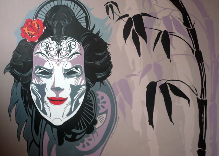 Geisha with an ornamented white face and a red rose in her hair beside bamboo
